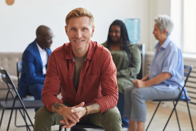 Group therapy session with men sharing and supporting each other